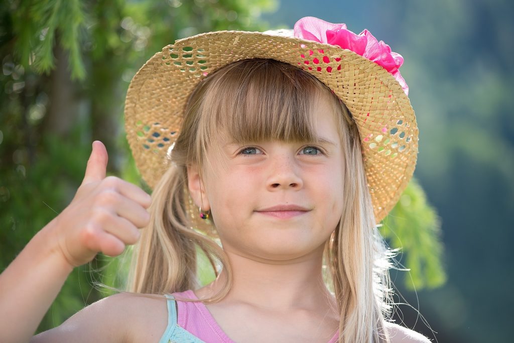 Image of a young girl holding up her thumb