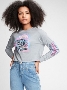 Image of a teen girl model wearing a grey graphic long sleeve t-shirt in a 'Back To The Future' film style print. This collection is made to help save water and reduce waste.