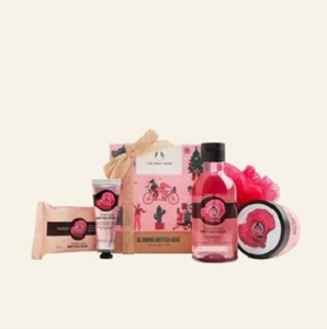 Image of The Body Shop's Glowing British Rose little gift box. Contains shower gel, body yoghurt, hand cream, soap and a mini bath lily made with recycled plastic.