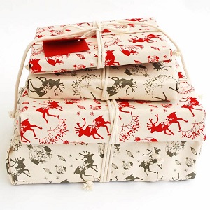 Image of reusable Christmas gift wrap fabric, print is multiple reindeers on a plain background, to help you be more eco friendly