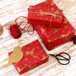 Image of recycled Christmas wrapping paper, print is multiple gold festive robin's on a red background, to help you be more eco friendly