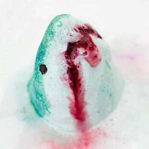 Image of a shark shaped bath bomb in water, fizzing away with colourful bubbles. This will make bath time loads of fun, whist being eco-conscious.